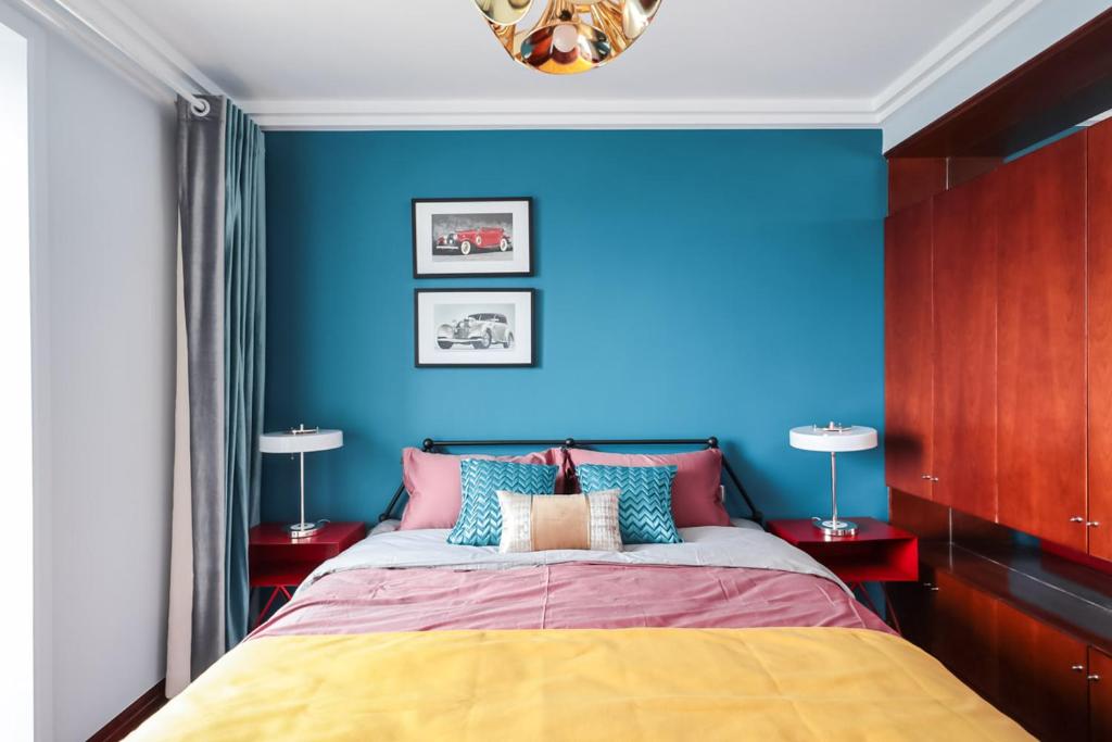 1 dormitorio azul con 1 cama y 2 lámparas en NanJing GuLou·Lion Bridge· Locals Apartment 00152470, en Nanjing
