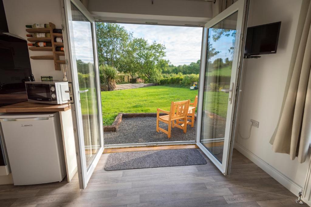 eine offene Glasschiebetür mit Blick auf einen Hof in der Unterkunft Riverside Cottage in Carrickfergus