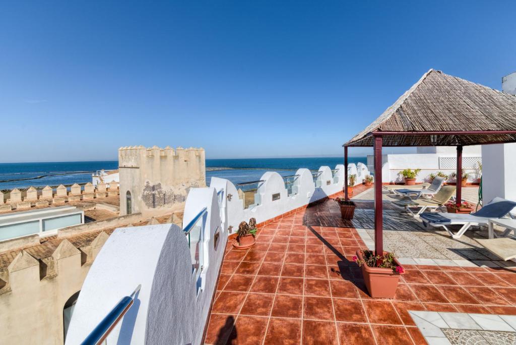 
a beach with a row of chairs and umbrellas at Hotel La Española in Chipiona
