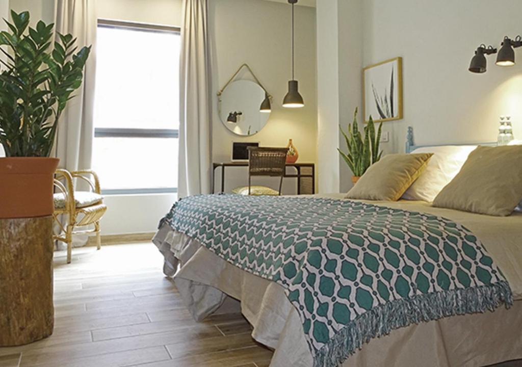 1 dormitorio con cama, mesa y ventana en Vicente Home, en Alcantarilla