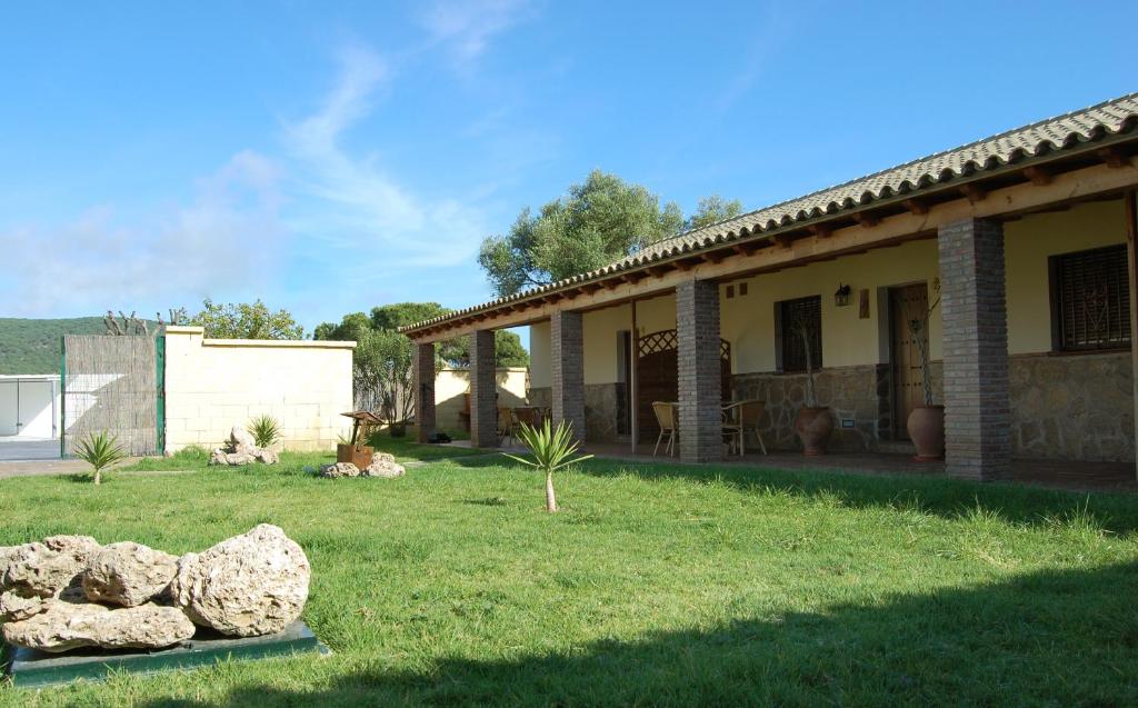 a house with some rocks in the yard at Residencial La Teja in Zahora