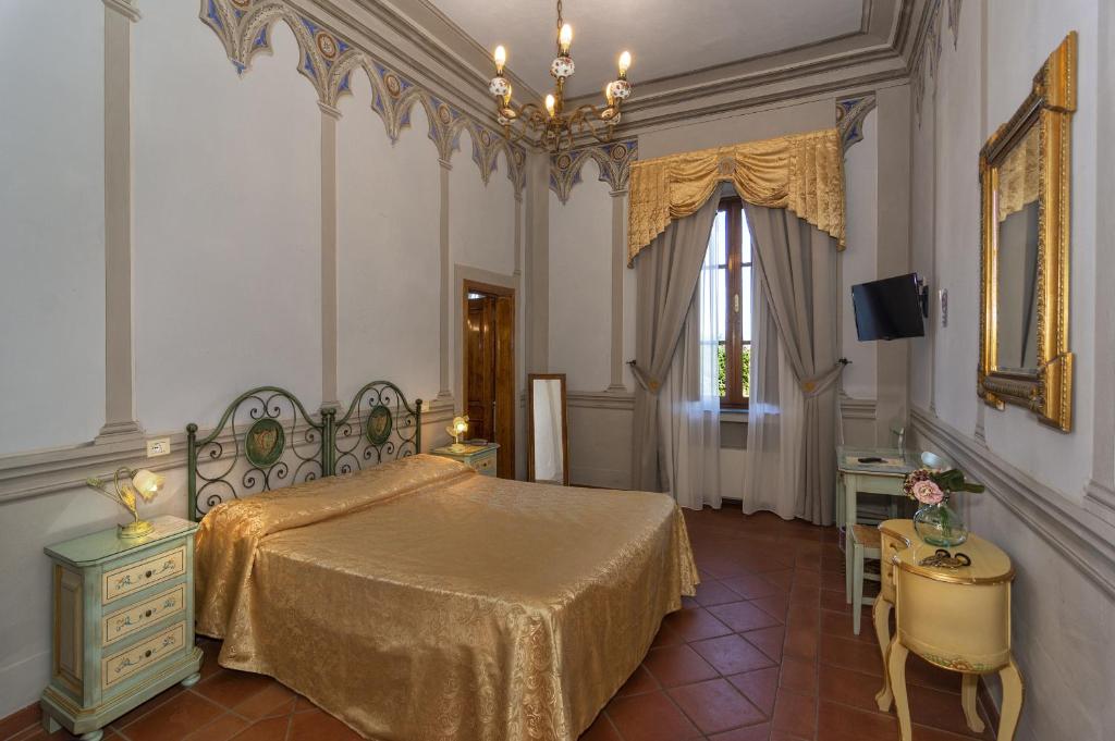 a bedroom with a bed and a table and a window at Hotel Villa Cheli in Lucca