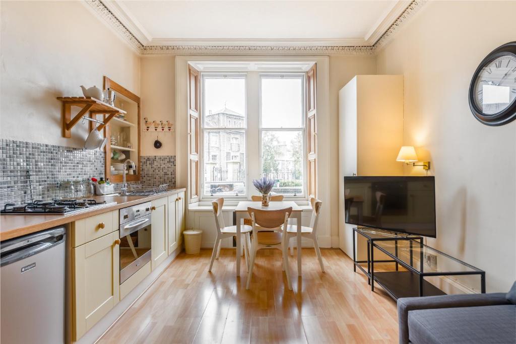 a kitchen with a table and a dining room at Spacious & Unique city central 1 bed with WiFi in Edinburgh