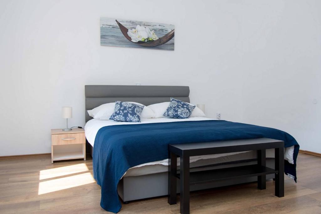 a bedroom with a bed with a blue blanket at Apartman Park in Daruvar