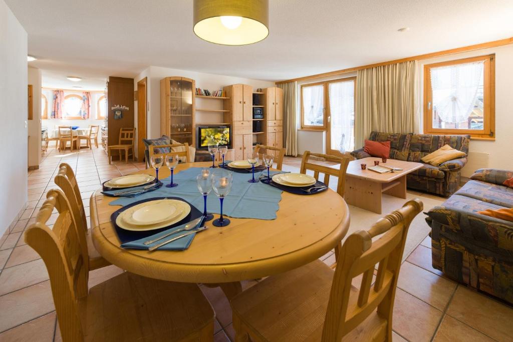 een eetkamer en een woonkamer met een tafel en stoelen bij Paradiso 2 in Grächen