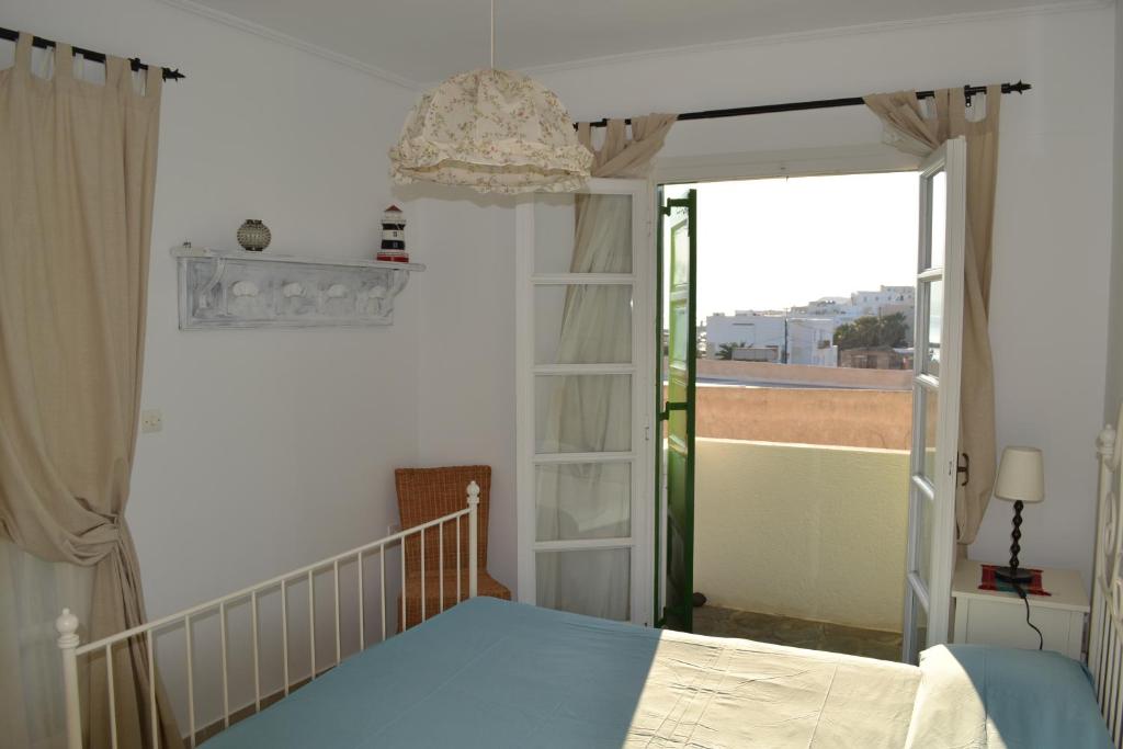 Schlafzimmer mit einem Bett und einer Tür zu einem Balkon in der Unterkunft Teresa Spiti in Adamas
