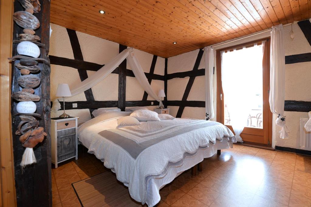 RorschwihrにあるChambres d'hôtes Fahrer-Ackermannの木製の天井のベッドルーム1室(大型ベッド1台付)