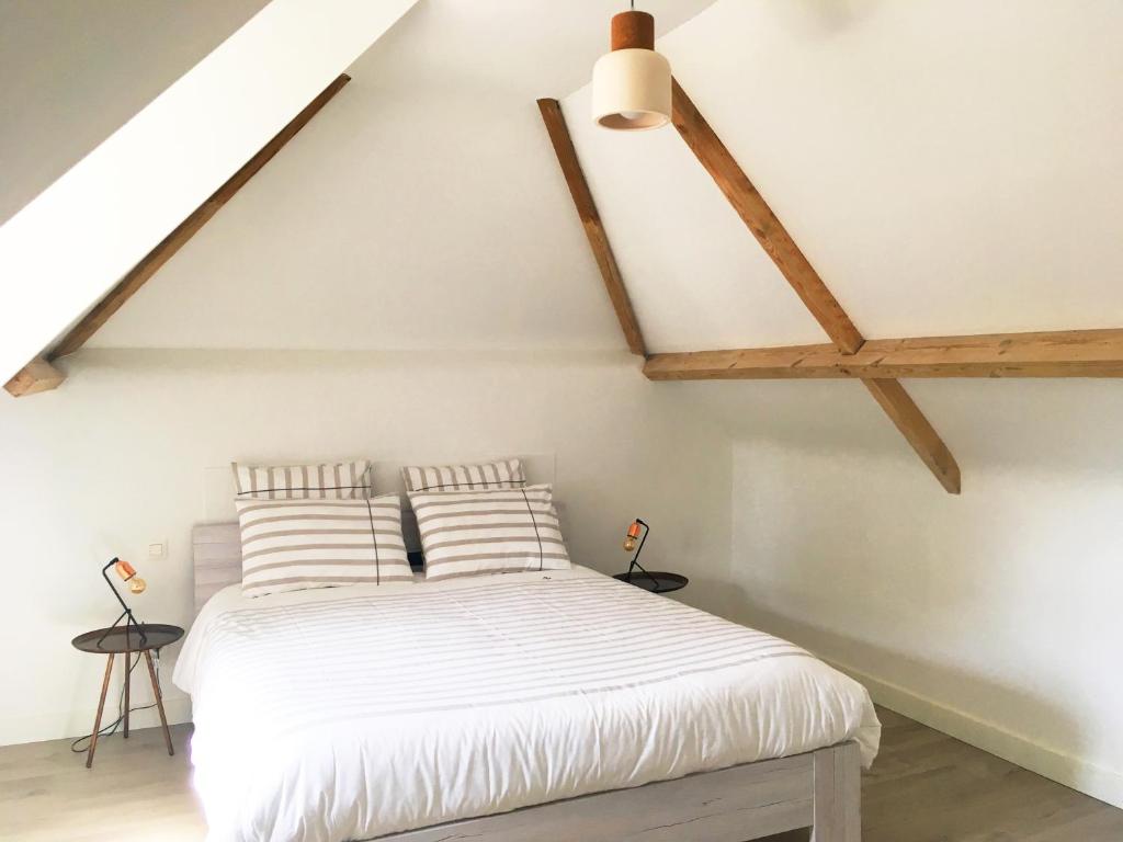 a bedroom with a white bed in a attic at B&B Villa Bon Papa in De Panne