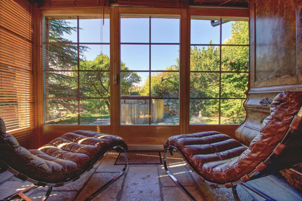 a room with two chairs and a large window at Magnifique chalet familial pour 10 personnes au coeur de Nax in Nax