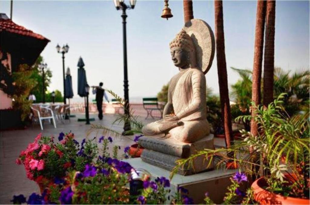 uma estátua de um Buda sentada num jardim em Brightland Resort & Spa em Mahabaleshwar