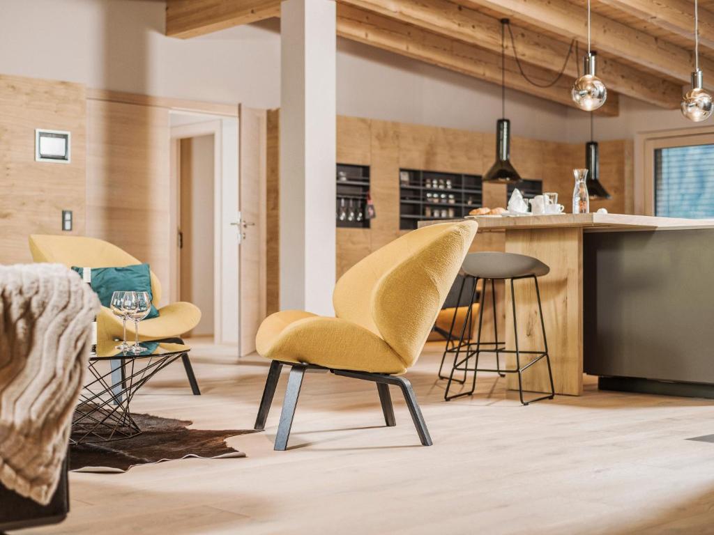a living room with yellow chairs and a counter at Postresidenz in Mayrhofen