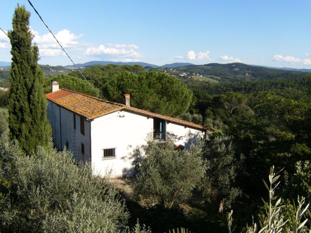 una piccola casa bianca in mezzo agli alberi di "Alle Montanine" Sughera a Firenze