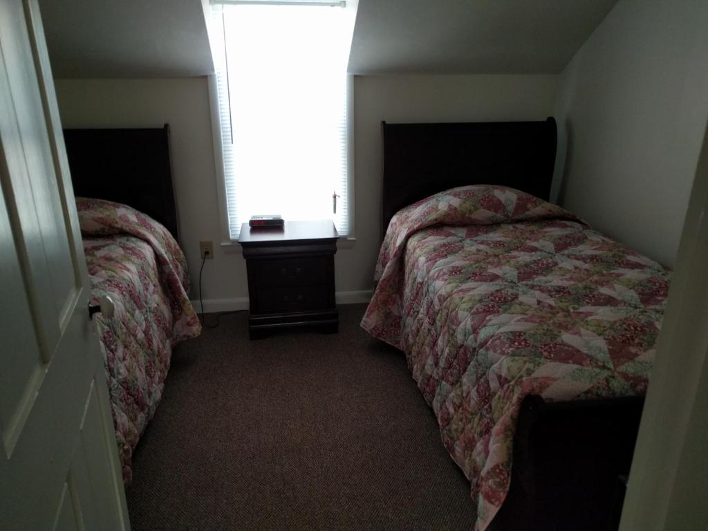 a small bedroom with two beds and a window at Pearl's Place in Gettysburg