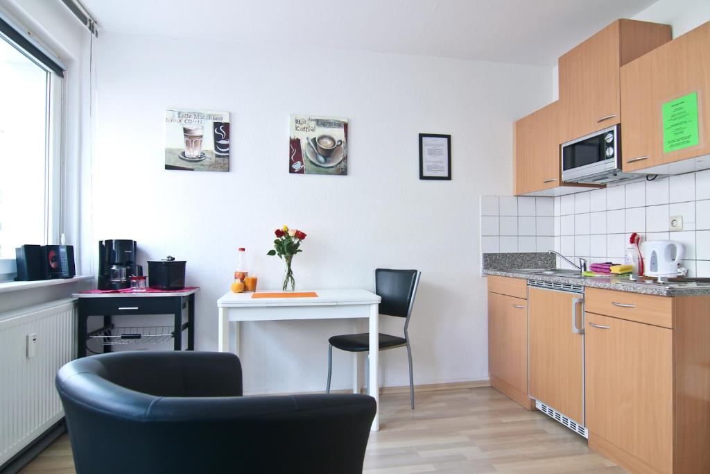 a small kitchen with two chairs and a table at Top Apartments in zentraler Lage in Cologne
