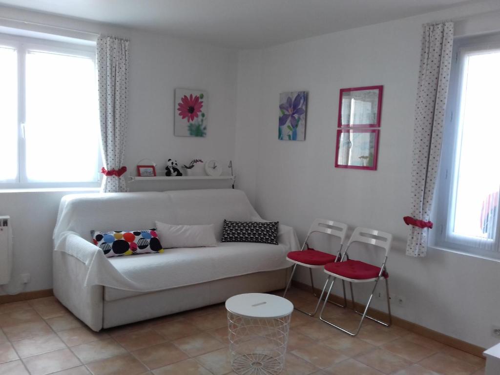 a living room with a white couch and two chairs at L'Amboiselyne in Amboise