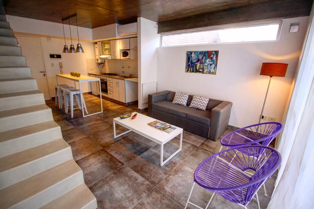uma sala de estar com um sofá, uma mesa e cadeiras em Dúplex 2 las Marías em San Salvador de Jujuy