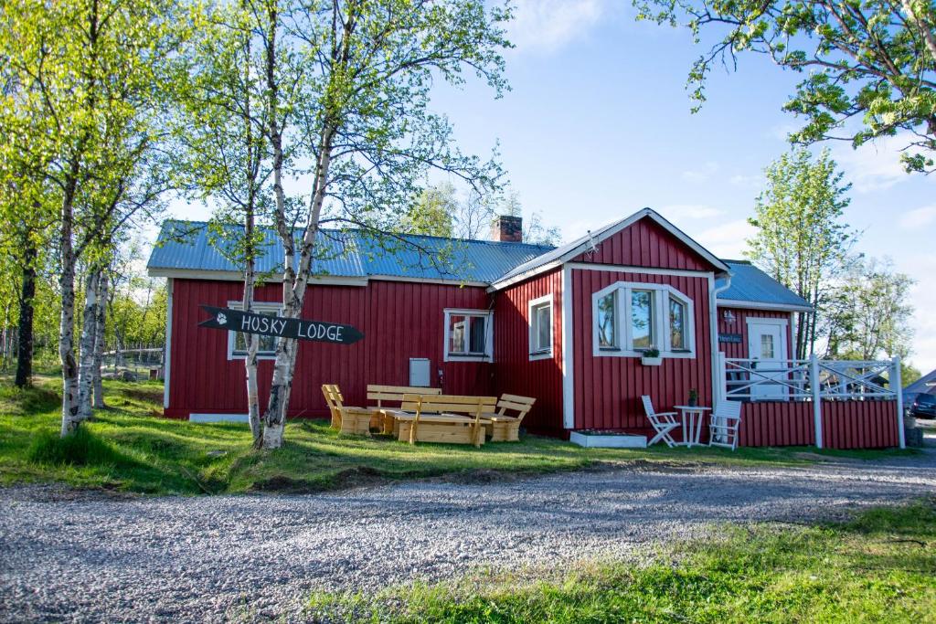 a red house with a picnic table in front of it at Husky Lodge Hostel in Kiruna