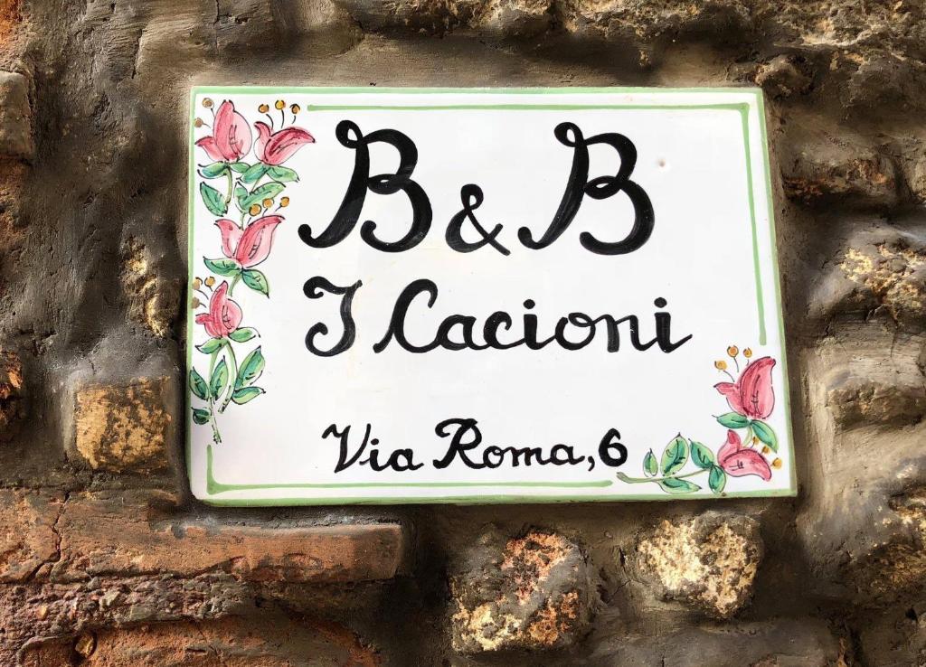 a sign on a brick wall with flowers on it at B&B I Cacioni in Civitella San Paolo