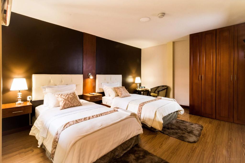 a hotel room with two beds and two lamps at Hotel Boutique Castilla de Léon in Cuenca