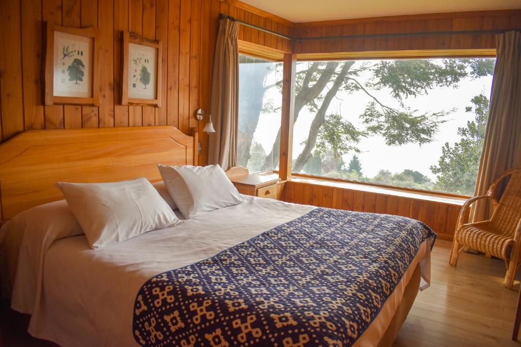 1 dormitorio con cama y ventana grande en Cabañas Monte Verde, en Pucón