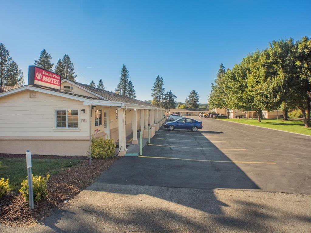 Burney的住宿－Shasta Pines Motel & Suites，停车场停在大楼前