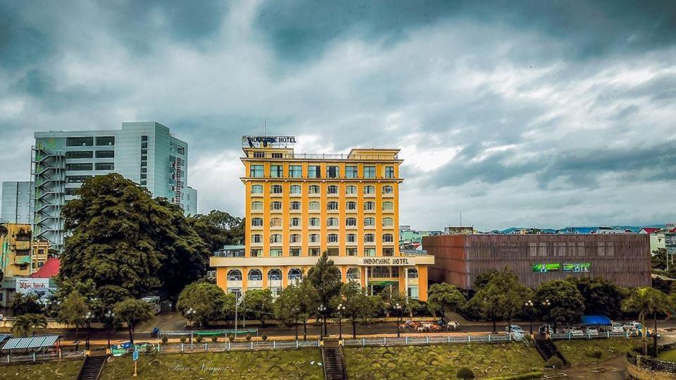 a large yellow building in the middle of a city at Indochine Hotel in Kon Tum