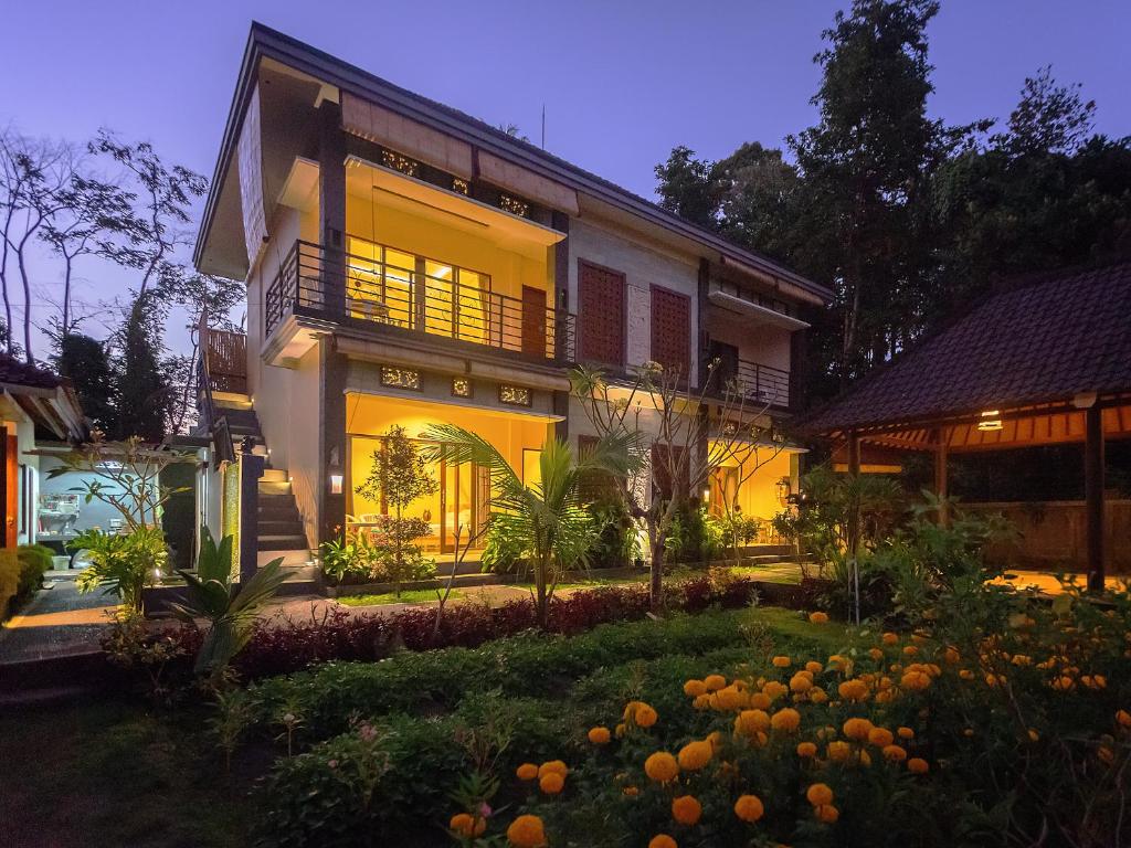 a house with a garden in front of it at Demank Hidden Guesthouse in Ubud