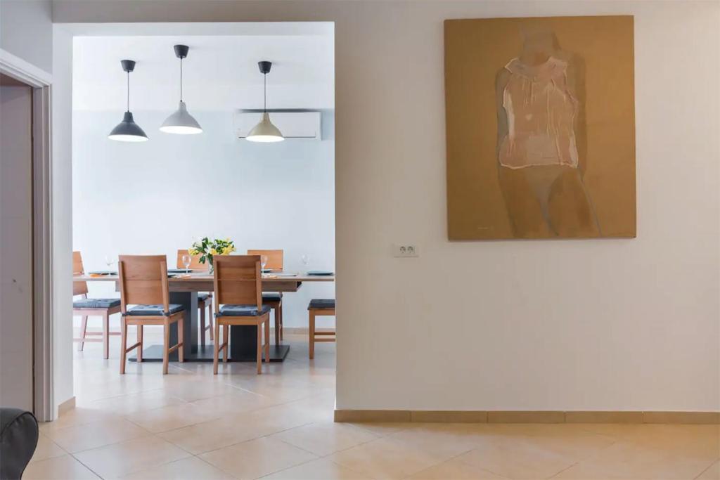 a dining room with a table and a painting on the wall at Apartments Hana in Pula