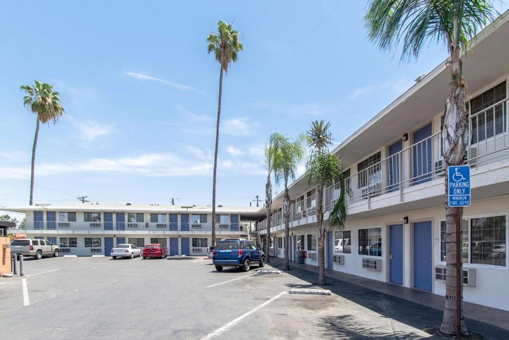 a parking lot in front of a building with palm trees at Motel 6 Bakersfield in Bakersfield