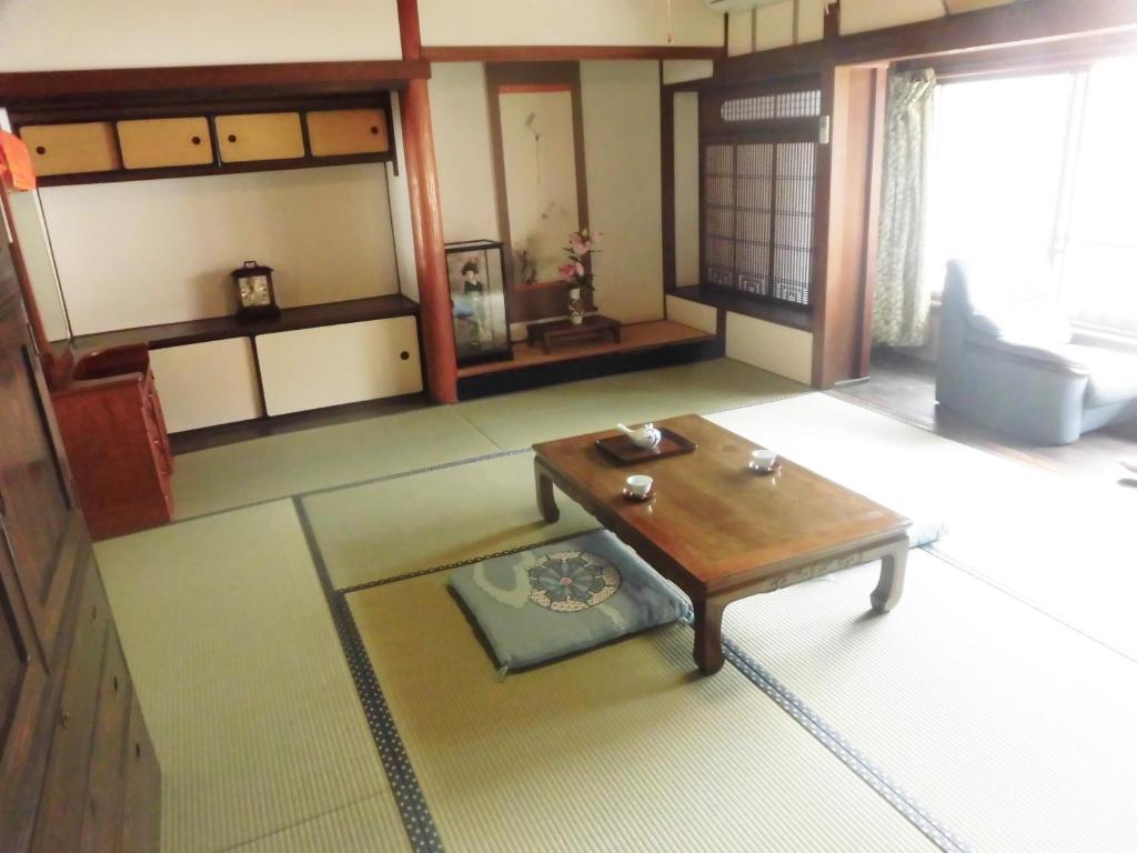 a living room with a table in a room at Share House Amigos in Onomichi