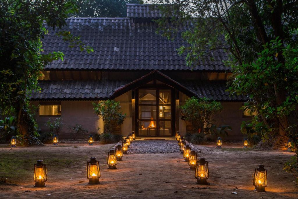 奇旺的住宿－Tiger Tops Tharu Lodge，通往前面灯的房子的通道