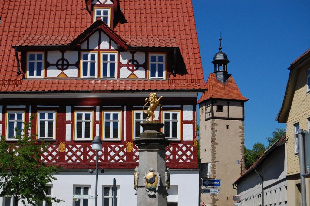 ein Gebäude mit rotem Dach und einem Uhrturm in der Unterkunft Ferienwohnung Veste Heldburg in Bad Rodach