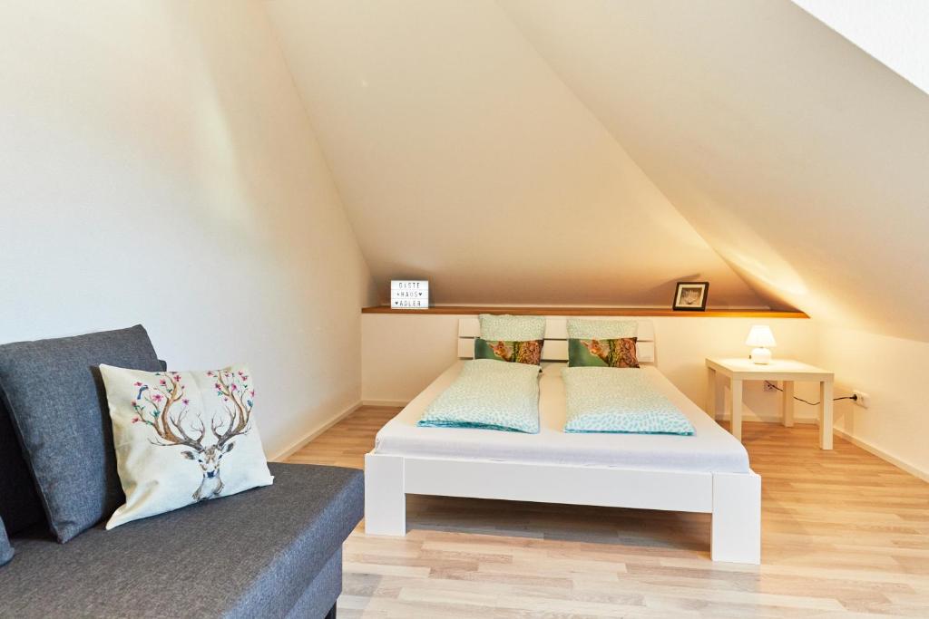 Cette chambre mansardée comprend un lit et un canapé. dans l'établissement Wohnung 1- nur 5 min. zum Europapark, à Ettenheim