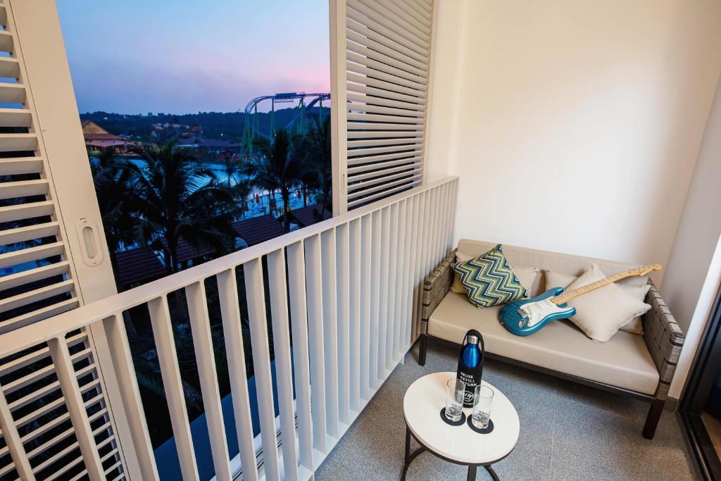 a balcony with a couch and a table with a view at Hard Rock Hotel Desaru Coast in Desaru