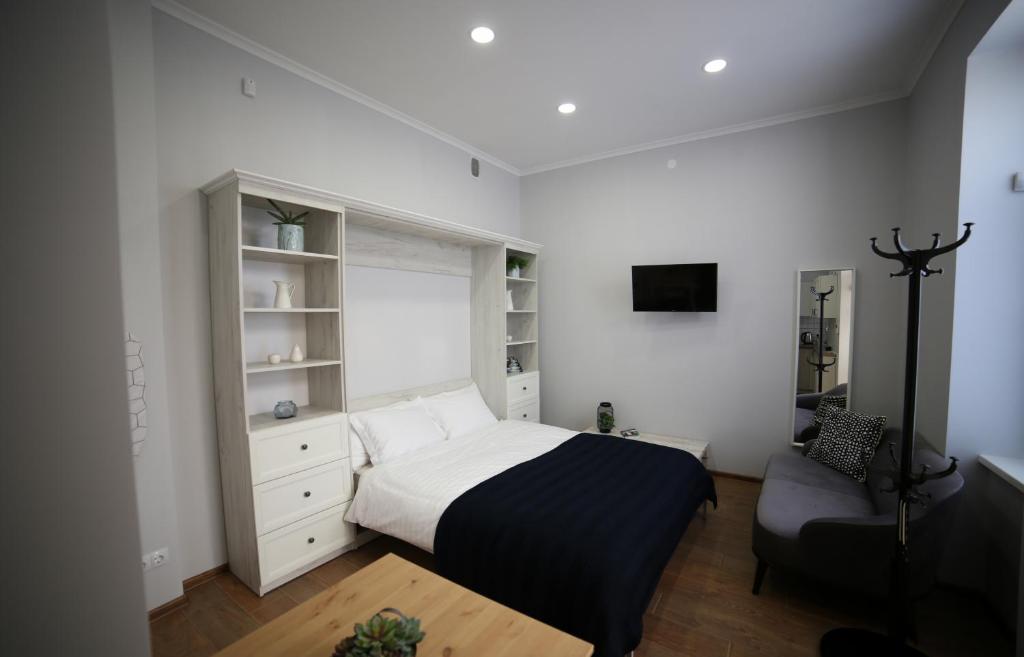 um quarto com uma cama e uma cadeira em Del Rey Comfort em Lviv