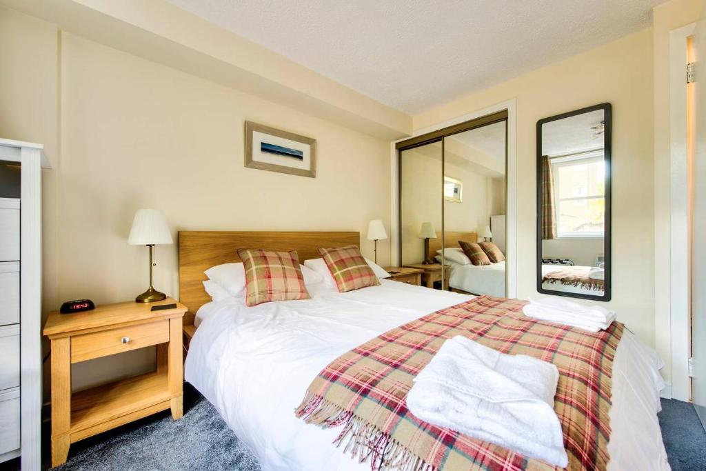 エディンバラにあるCharming 1 Bed Apartment with Castle Viewのベッドルーム(大型ベッド1台、鏡付)