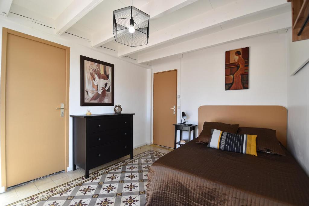 - une chambre avec un lit et une commode noire dans l'établissement Villa le 180 cinq, à Toulon