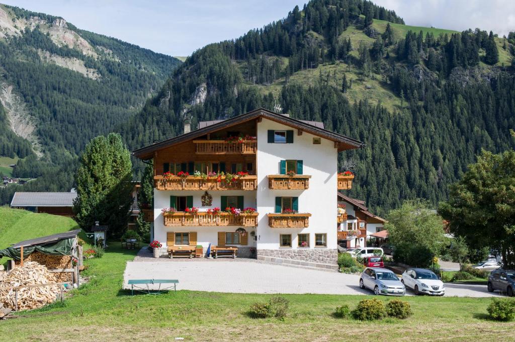 - un grand bâtiment avec balcon et fleurs dans l'établissement Villa Insam, à Selva di Val Gardena
