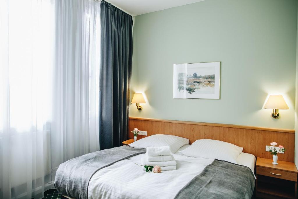 Hotel "Helle Mitte" Berlin في برلين: غرفة فندق عليها سرير وفوط