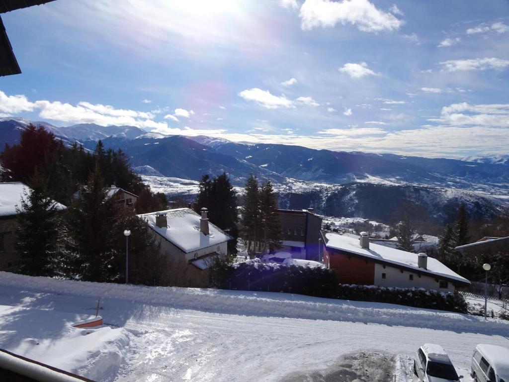 豐羅默奧代洛維亞的住宿－Les Sorbiers - Grand T4 ensoleillé avec Vue Panoramique，享有雪覆盖的山丘和山脉的景色。
