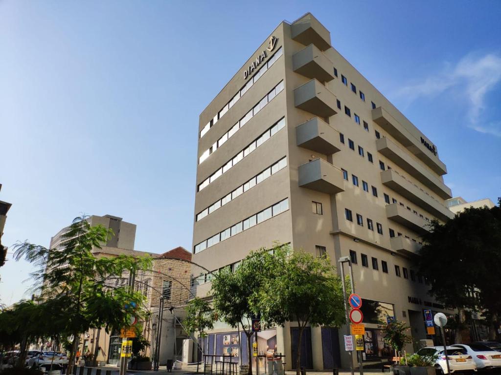 un edificio blanco alto en una calle de la ciudad en Diana Hotel en Haifa