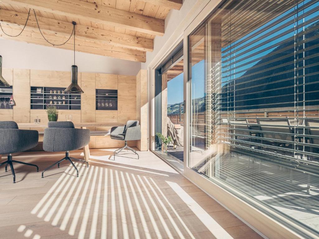 a room with a table and chairs and a large window at Postresidenz in Mayrhofen