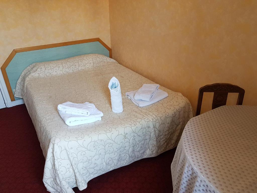 a hotel room with two beds with towels on them at Hotel de la Gare in Dol-de-Bretagne