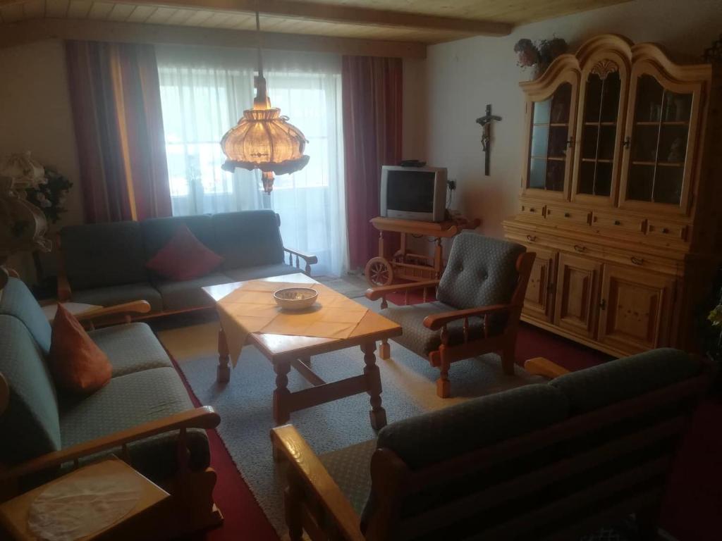 - un salon avec des canapés, une table et une télévision dans l&#39;établissement Haus Pechtl, à Sankt Leonhard im Pitztal