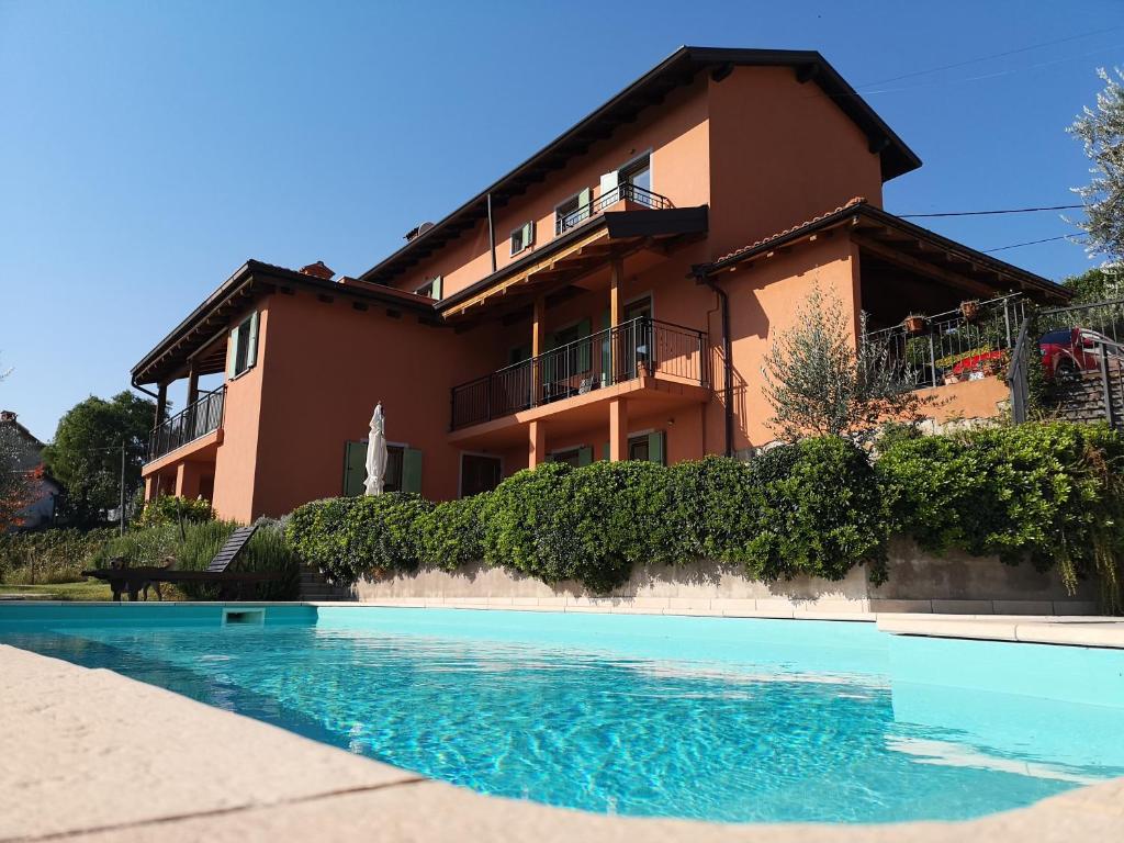 a house with a swimming pool in front of a building at Zoi Apartments in Dobrovo