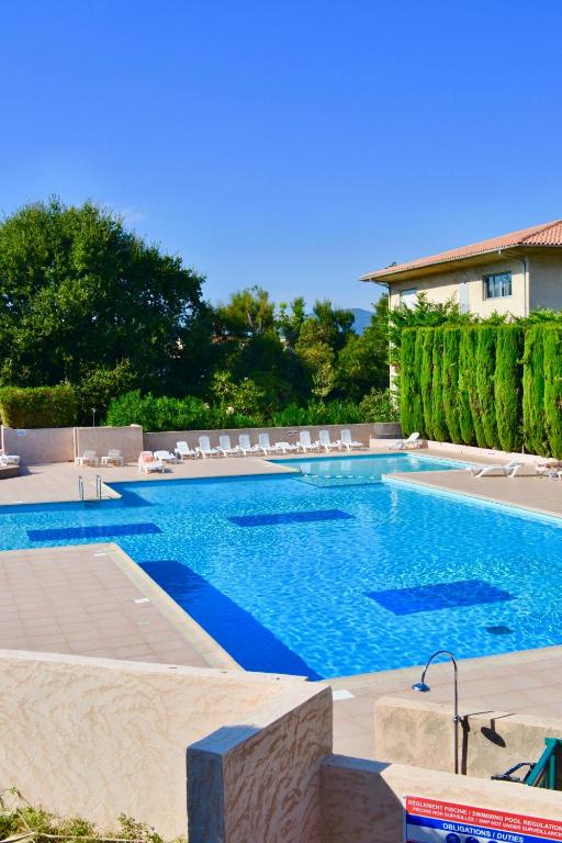 une grande piscine avec des chaises longues dans l'établissement Apartment Eden Park, à Saint-Tropez