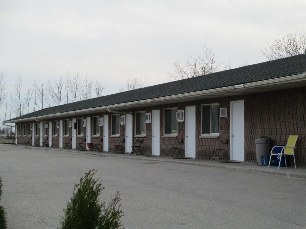 a building with a lot of windows and a parking lot at Newburg Inn Motel in New Hamburg