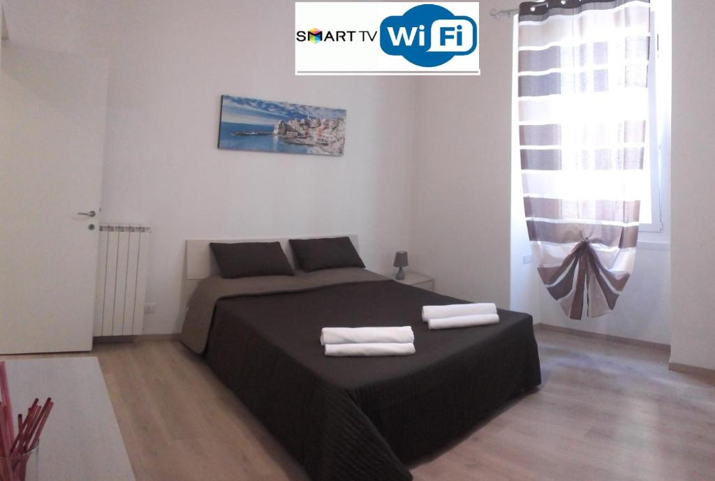 een slaapkamer met een bed met twee handdoeken erop bij Alysia Apartment in Genua