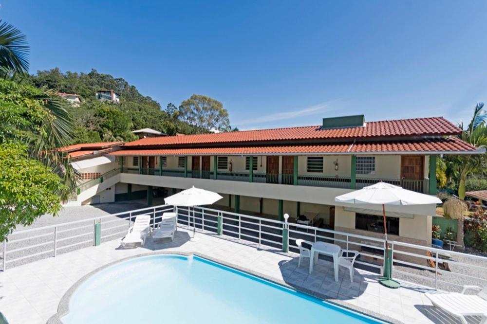 a resort with a swimming pool and a building at Pousada Dona Ema in Balneário Camboriú