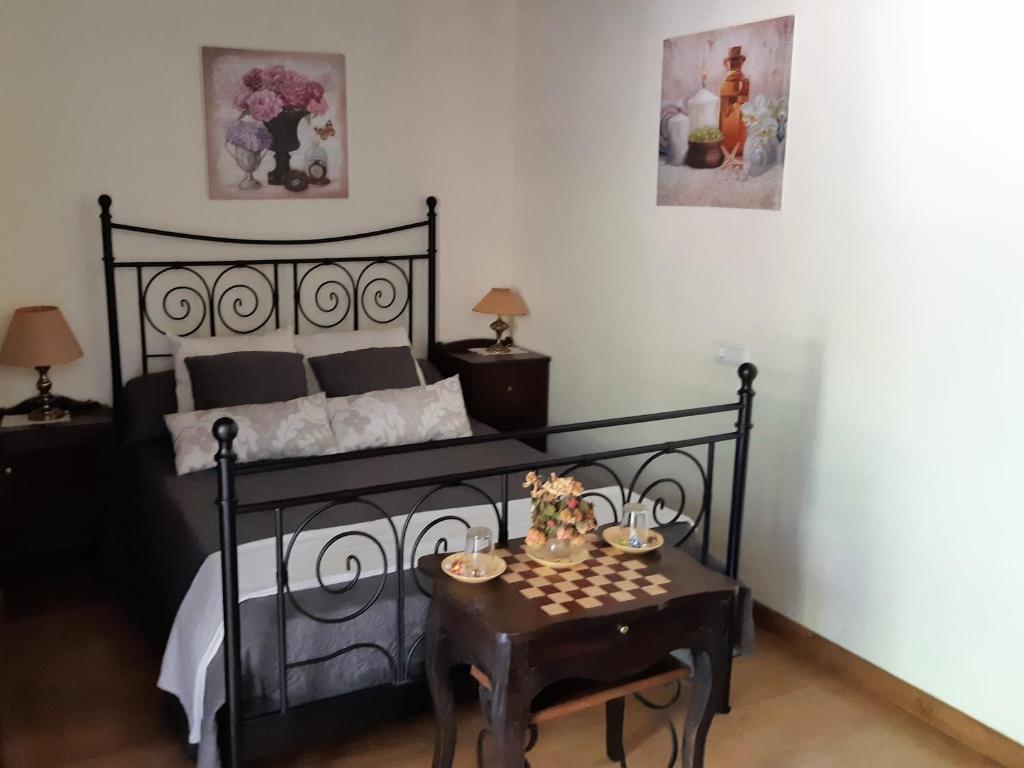 a bedroom with a black bed and a table at Hospedaje - Ferrería Quintá in Quiroga